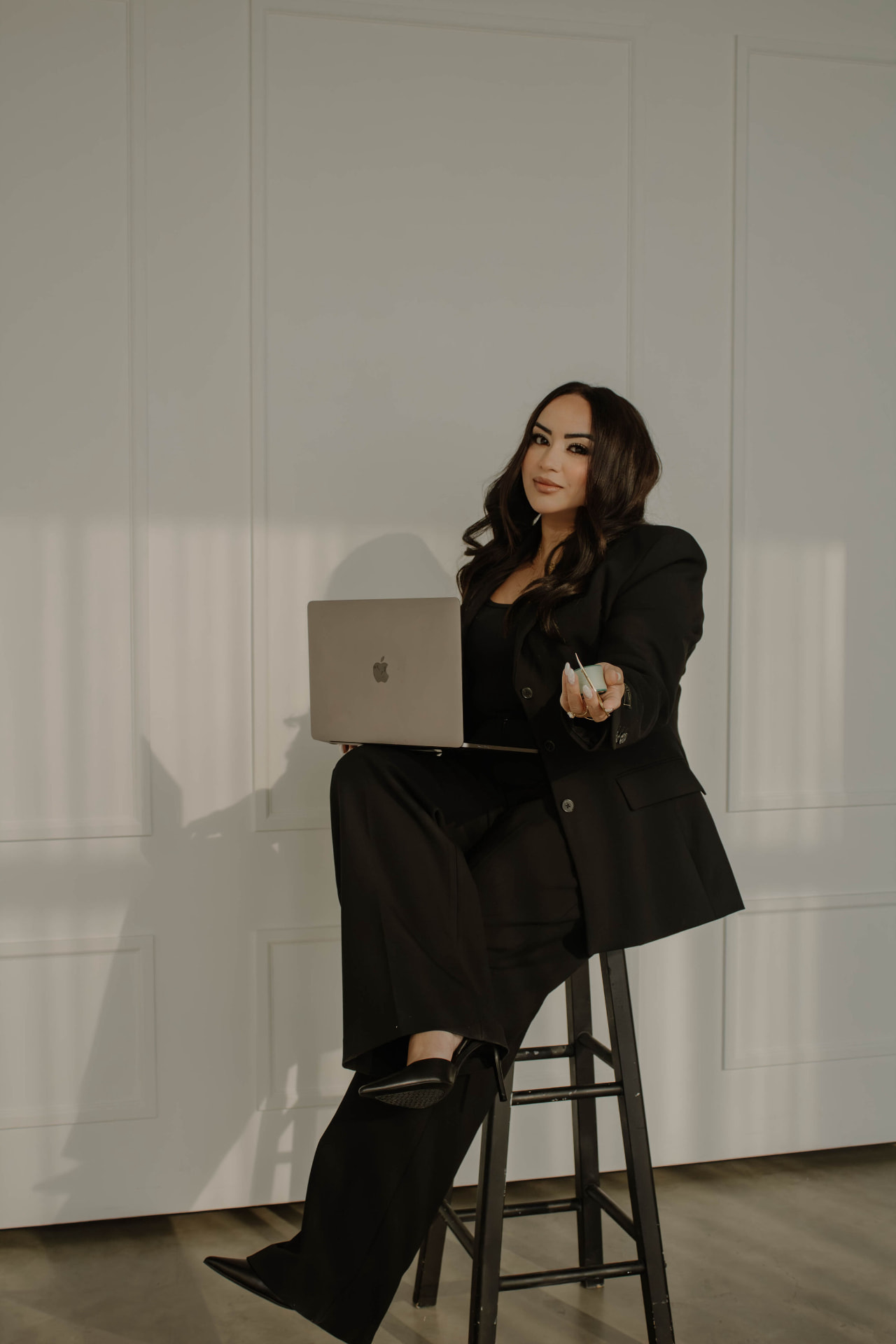 Gagan, founder of Maison Aesthetics, in a tailored black suit in a bright studio